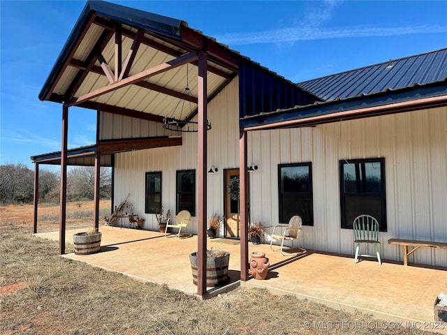 rear view of house featuring metal roof and a patio area