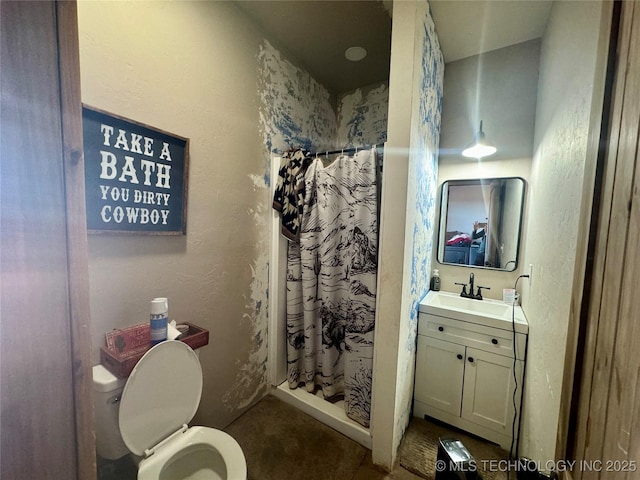 bathroom with a textured wall, vanity, toilet, and a shower with curtain