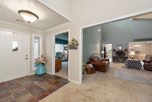 carpeted foyer with wooden ceiling, an inviting chandelier, plenty of natural light, and ornamental molding