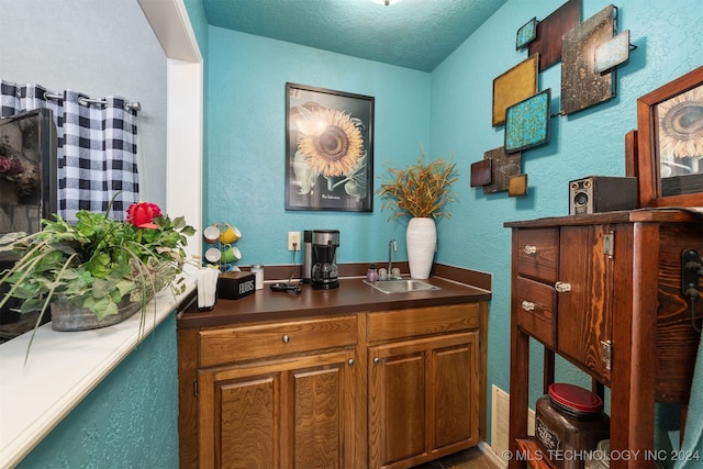 bar with a textured ceiling and sink