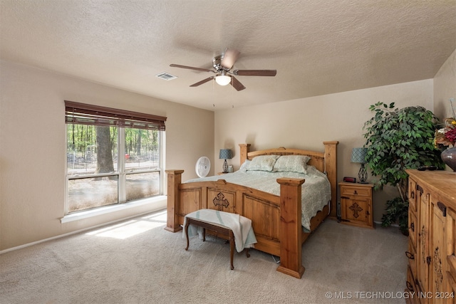 carpeted bedroom featuring a textured ceiling and ceiling fan