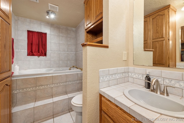 bathroom with tile patterned flooring, vanity, toilet, and a textured ceiling