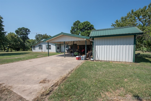 view of outbuilding featuring a yard and a carport