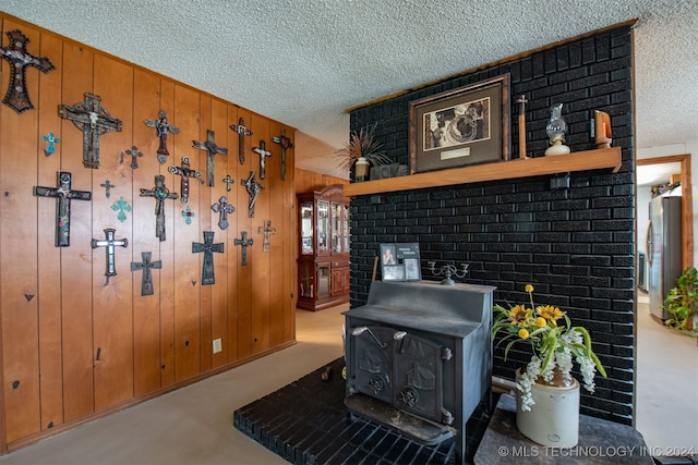 details with wood walls, a wood stove, and a textured ceiling