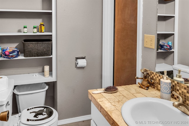 bathroom with vanity, toilet, and tasteful backsplash