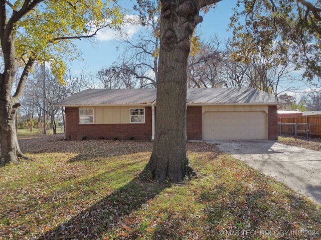 single story home featuring a garage and a front lawn