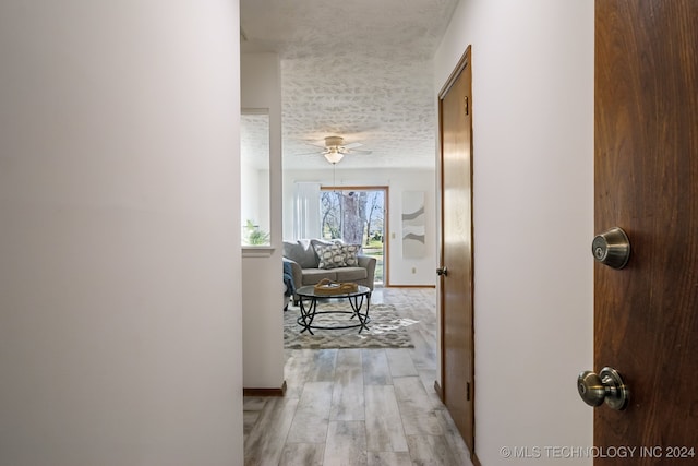 hallway featuring a textured ceiling and light wood-type flooring