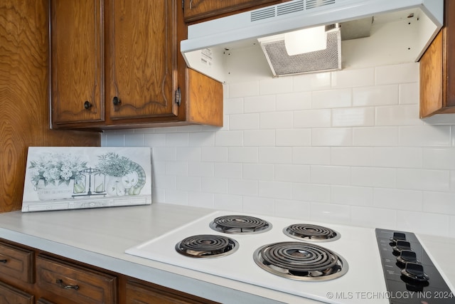 kitchen with backsplash, ventilation hood, and white electric stovetop