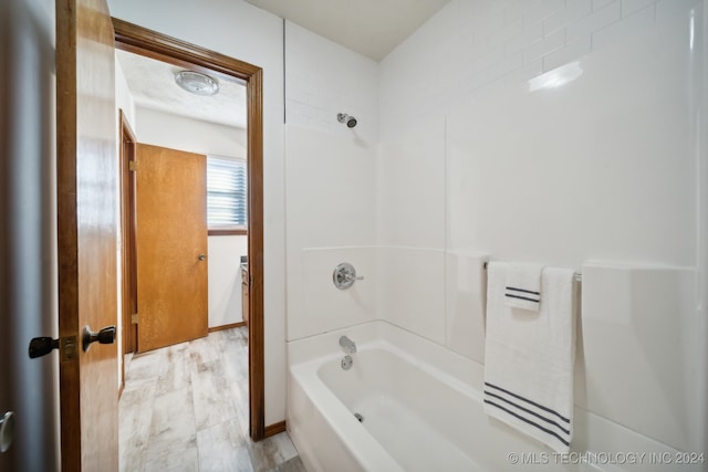 bathroom featuring shower / washtub combination and hardwood / wood-style flooring