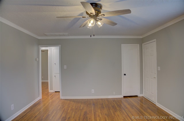 empty room featuring hardwood / wood-style floors, a textured ceiling, ceiling fan, and ornamental molding