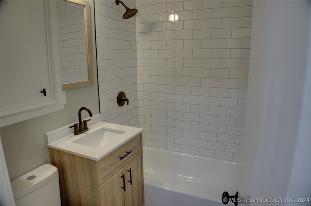 full bathroom featuring tiled shower / bath combo, toilet, and vanity