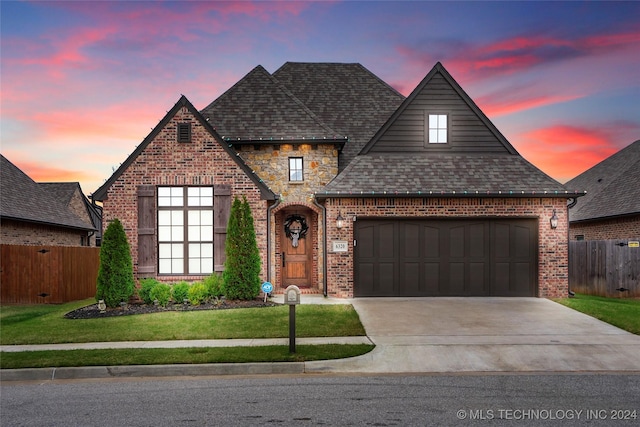 view of front of property featuring a garage and a lawn