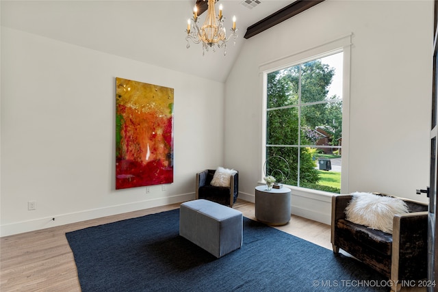 living area featuring hardwood / wood-style floors, an inviting chandelier, and lofted ceiling