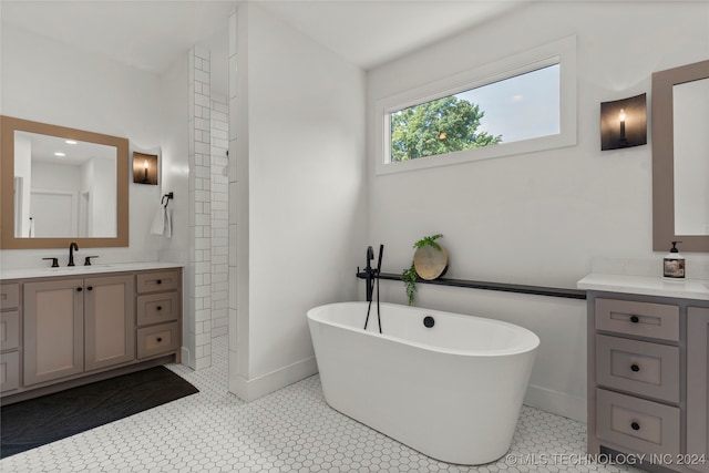 bathroom with a bathtub, vanity, and tile patterned flooring