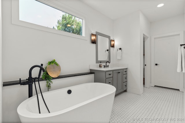 bathroom featuring vanity, tile patterned floors, and a tub