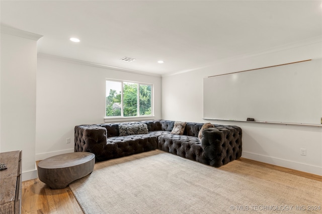 living room with crown molding and light hardwood / wood-style flooring