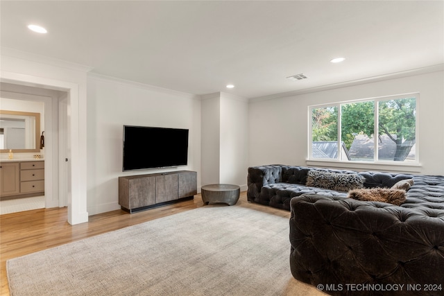 living room with crown molding and light hardwood / wood-style floors