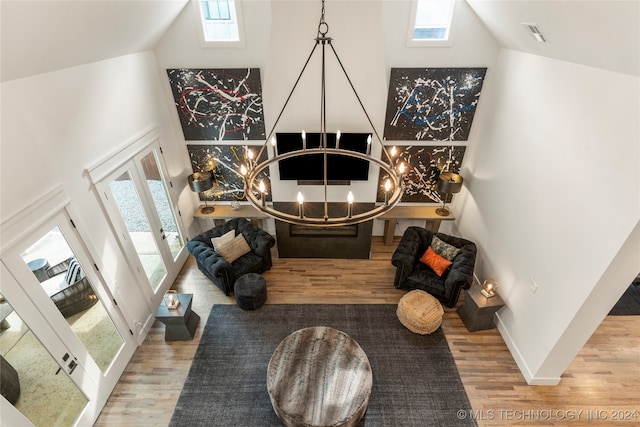 foyer entrance featuring a chandelier, french doors, a healthy amount of sunlight, and hardwood / wood-style flooring