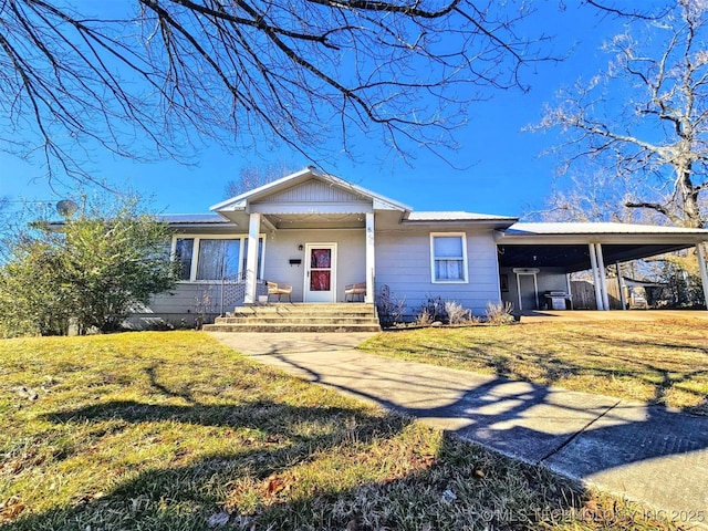 single story home with a carport, a porch, and a front lawn