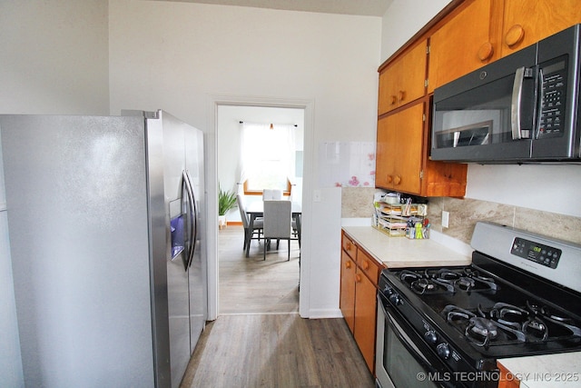 kitchen featuring stainless steel appliances and dark hardwood / wood-style flooring