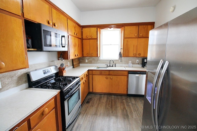 kitchen with dark wood-type flooring, appliances with stainless steel finishes, sink, and tasteful backsplash