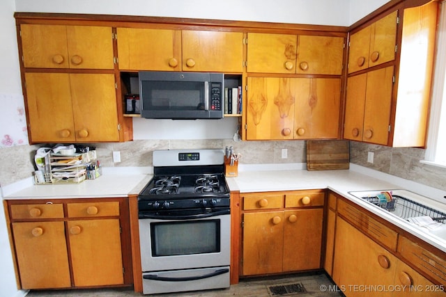 kitchen with stainless steel range with gas stovetop and decorative backsplash