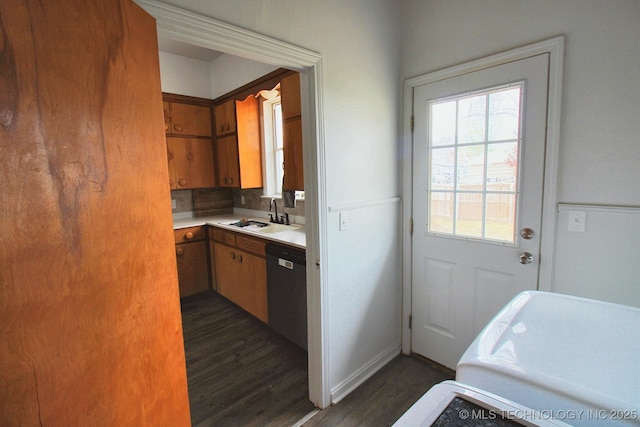 kitchen with dishwasher, sink, dark hardwood / wood-style floors, and decorative backsplash