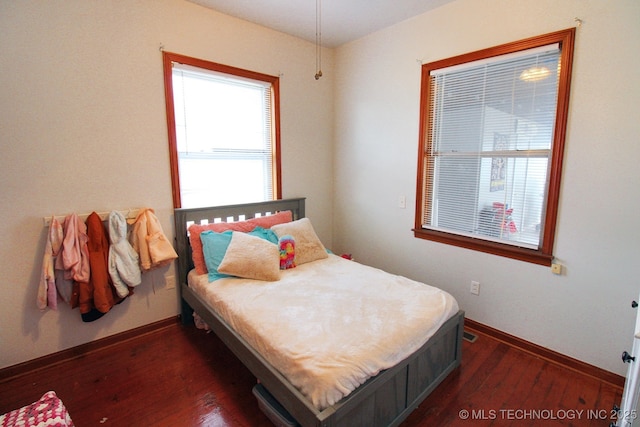 bedroom with dark wood-type flooring