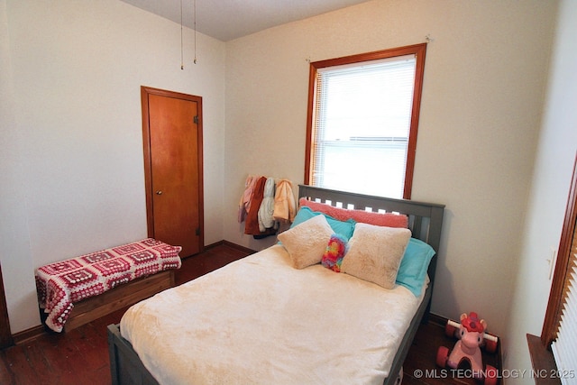 bedroom with dark hardwood / wood-style floors