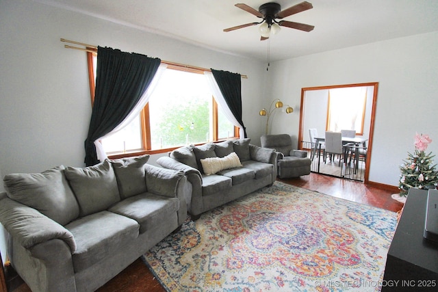 living room featuring dark wood-type flooring and ceiling fan