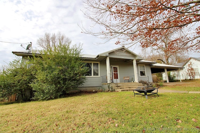 view of front of house with a fire pit and a front lawn