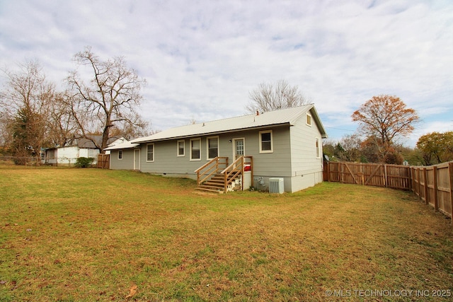 back of house featuring a yard and central AC