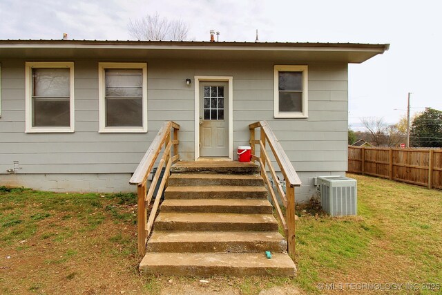 exterior space featuring central AC unit and a yard