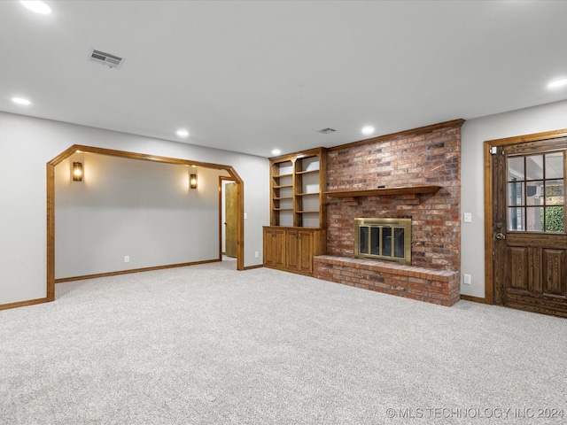 unfurnished living room featuring a fireplace and light colored carpet