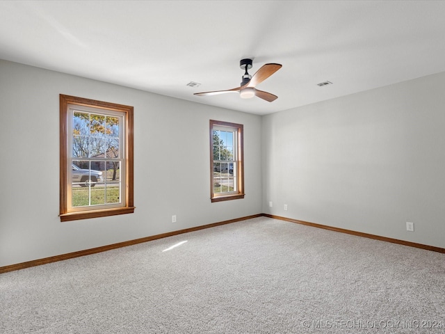 carpeted spare room featuring ceiling fan