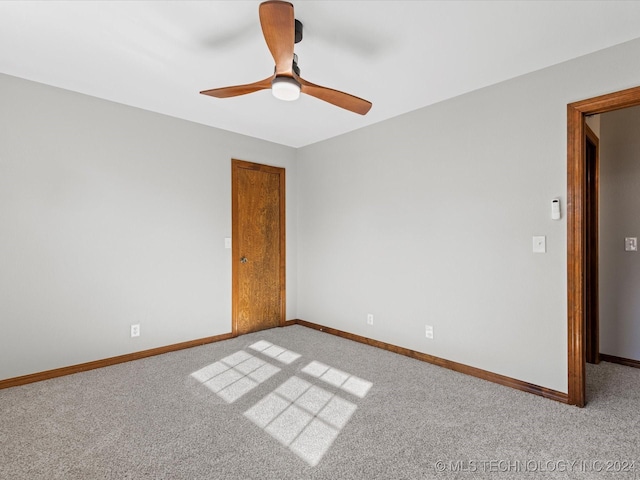 empty room featuring light colored carpet and ceiling fan