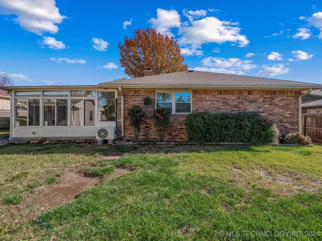 back of house featuring a sunroom, ac unit, and a lawn