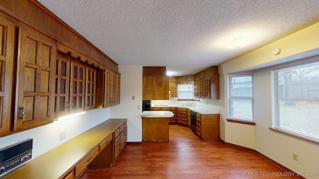 kitchen featuring dishwasher, a textured ceiling, dark wood-type flooring, and sink