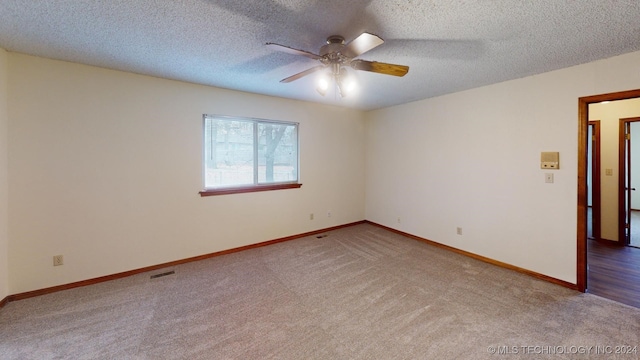 carpeted spare room featuring ceiling fan and a textured ceiling