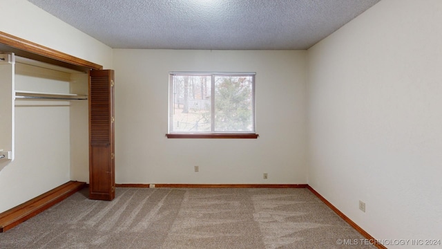 unfurnished bedroom with light colored carpet, a textured ceiling, and a closet