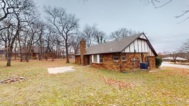 view of side of property with a lawn and cooling unit