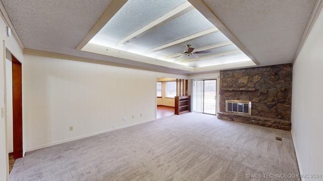 unfurnished living room with a tray ceiling, ceiling fan, a fireplace, and a textured ceiling