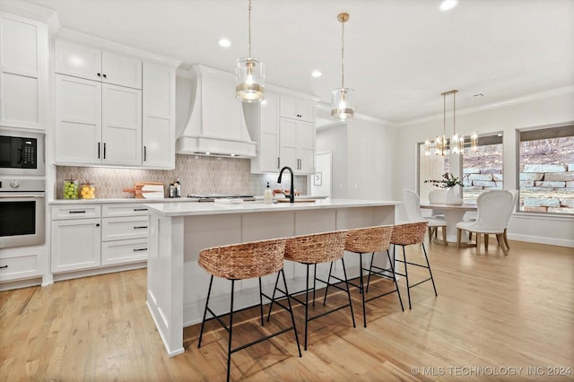 kitchen with white cabinets, stainless steel oven, custom exhaust hood, and black microwave