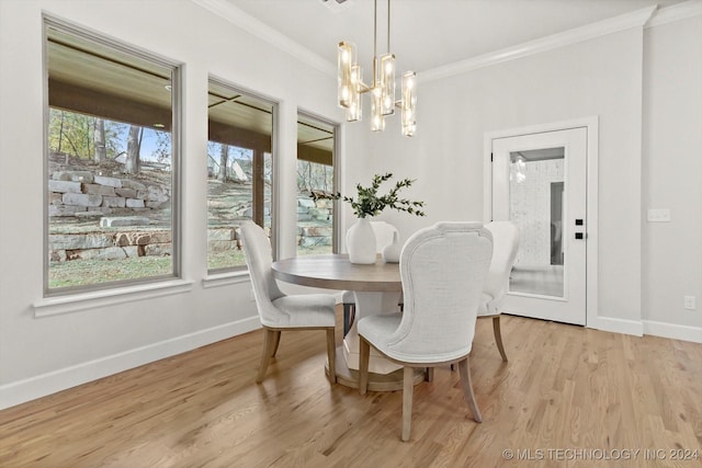 dining area featuring an inviting chandelier, crown molding, and light wood-type flooring