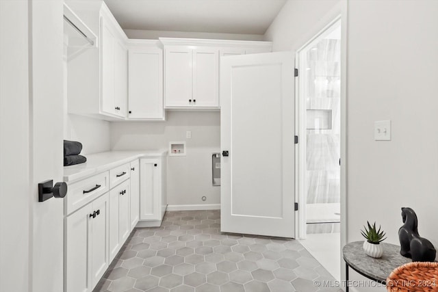 laundry room featuring tile patterned flooring, hookup for a washing machine, and cabinets