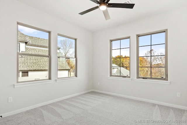 carpeted spare room with plenty of natural light and ceiling fan