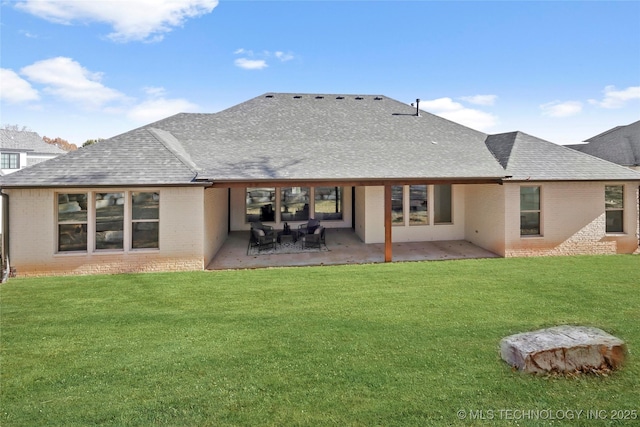 rear view of property with a yard and a patio area