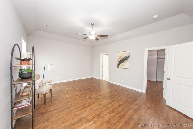 living area featuring ceiling fan, dark hardwood / wood-style flooring, and vaulted ceiling