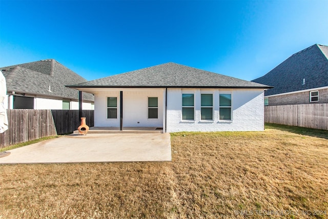 back of property featuring a yard and a patio