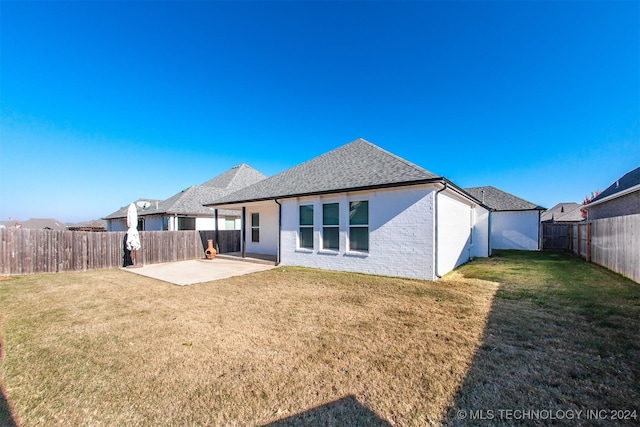 back of property with a patio area and a yard